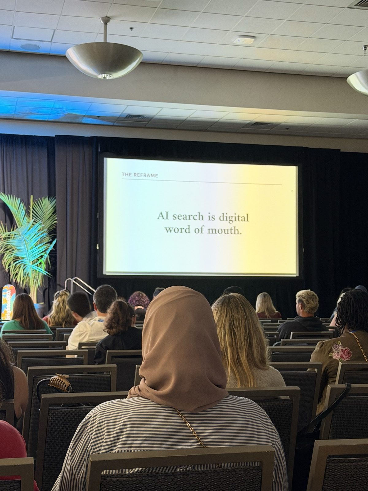 Slide con el rótulo 'The reframe' y la frase 'AI search is digital word of mouth.'