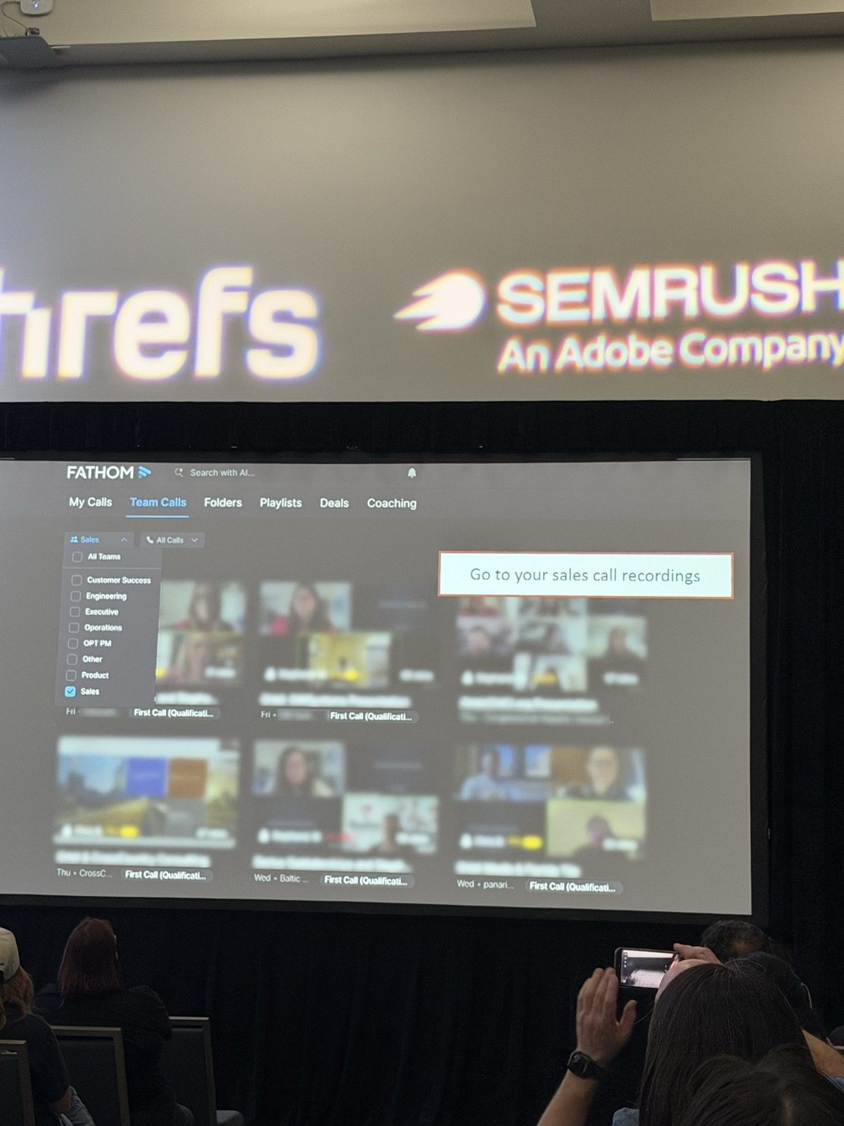 Captura de Fathom con la pestaña Team Calls, filtro de equipos con Sales tildado, grilla de grabaciones etiquetadas First Call (Qualification) y el recuadro 'Go to your sales call recordings'